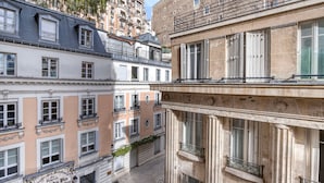 A multi-story building with balconies, a sign for the Musée du Vin, and a cobblestone street. - Blueground | Trocadéro, nr shops & Eiffel Tower (Paris)