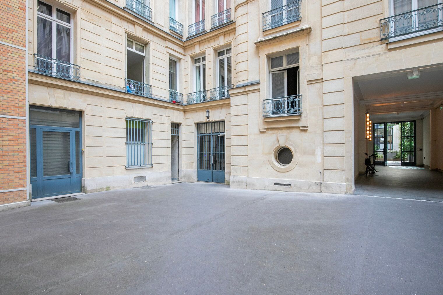 Une cour intérieure dotée d’un espace central ouvert, entourée de bâtiments comportant de nombreuses fenêtres et des balcons.