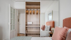 A bedroom with a bed, a wardrobe, and a bedside table. - Blueground | Montmartre, close to shops & cafes (Paris)