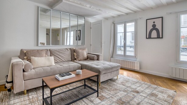 Ein modernes Wohnzimmer mit einer Couch, einem Couchtisch und einem großen Spiegel.