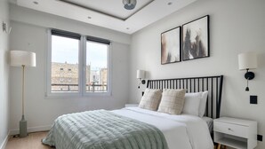 A modern bedroom with a large bed, a nightstand, a floor lamp, and two wall-mounted lamps. - Blueground | Mairie du XVI, balcony, nr dining (Paris)
