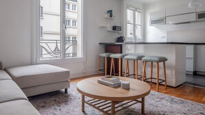 Un appartement moderne comprenant un salon, une cuisine et un balcon.