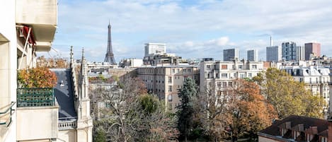 A view of Paris with the Eiffel Tower in the background, surrounded by residential buildings and trees.