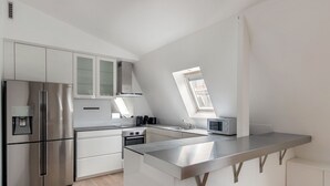 Une cuisine moderne équipée d’un réfrigérateur en acier inoxydable, d’un four encastré, d’un four à micro-ondes et d’un évier.