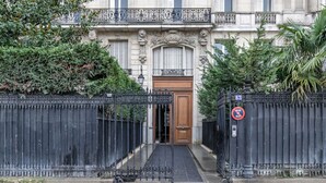 Une entrée fermée par un portail, avec une porte en bois, un portail en métal et un panneau indiquant qu’il est interdit de se garer.