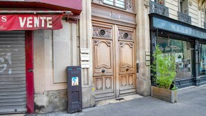 A storefront with a red awning labeled "VENTE" and a closed metal shutter. - Blueground | Pigalle, nr shopping & festive area (Paris)