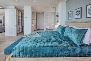 Ein geräumiges Schlafzimmer mit einem großen Bett, einem begehbaren Kleiderschrank und einem Badezimmer mit Marmorwand.