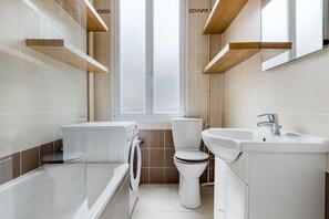 A modern bathroom with a bathtub, toilet, and sink. - Blueground | Jardin du Luxembourg, walk to gardens (Paris)