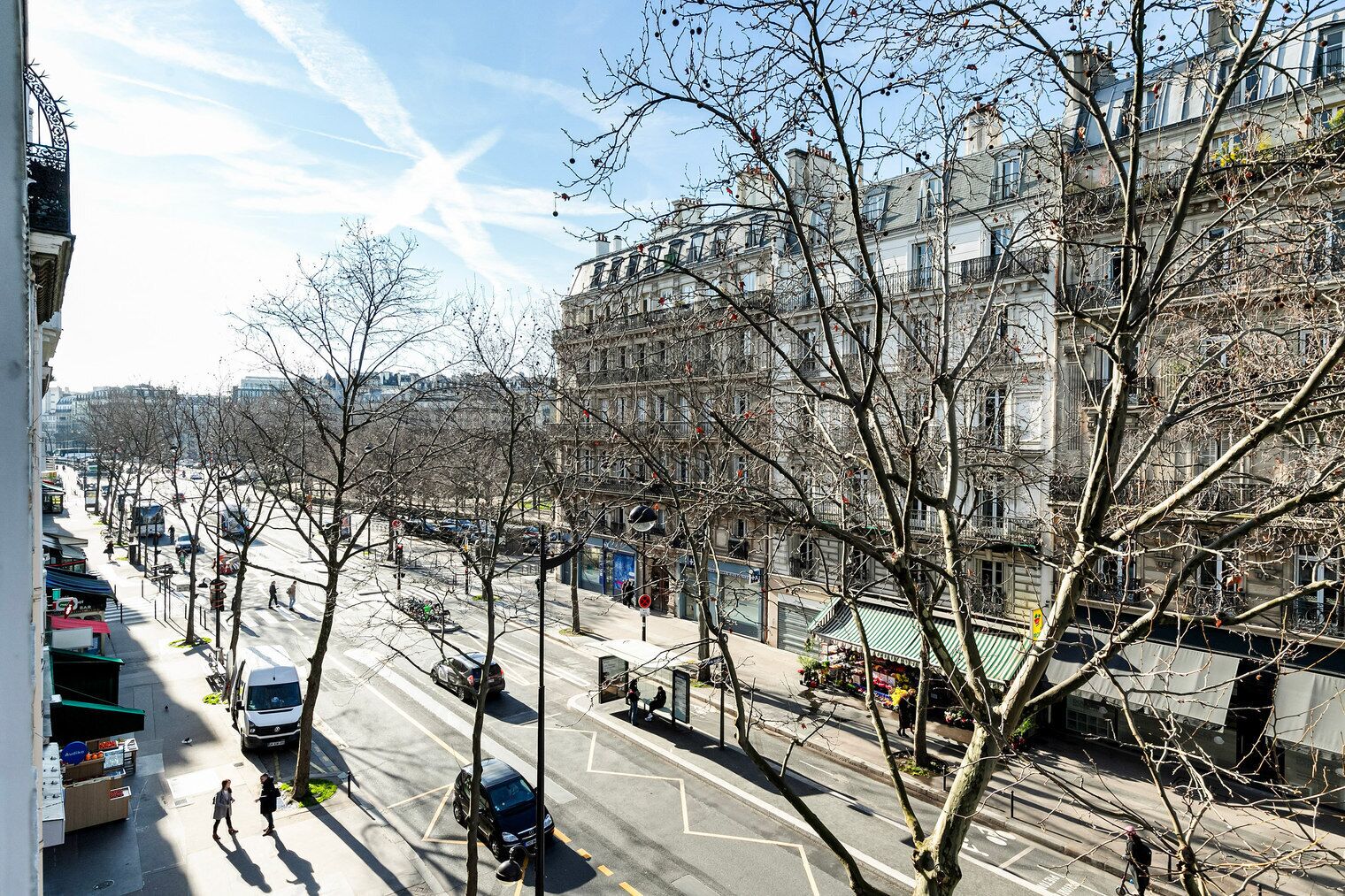 Vista de la calle con edificios, árboles y cielo despejado.