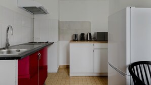 A compact kitchen with a sink, stove, and microwave. - Blueground | Jardin du Luxembourg, near gardens (Paris)