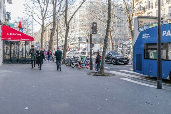 A city street with pedestrians, bicycles, and a blue bus.
