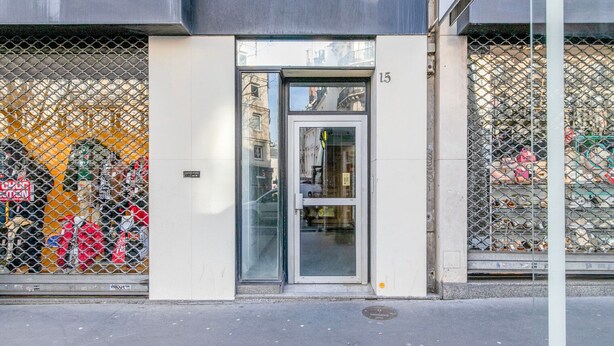 A building entrance with a glass door and a metal fence. - Blueground | Quartier Latin, near gardens (Paris)