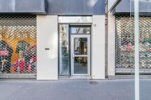 A building entrance with a glass door and a metal fence.