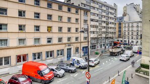 Un edificio residencial de varios pisos con fachada color beige, varias ventanas y balcones.