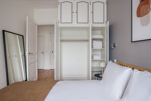 A bedroom with a bed, a wardrobe, and a door leading to another room. - Blueground | Miromesnil, near restaurants & shops (Paris)
