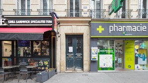 Un restaurant amb terrassa i una farmàcia al davant.