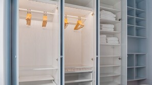 A walk-in closet with open shelves and hanging space, featuring a modern design and organized storage. - Blueground | Pigalle, nr dining & shopping (Paris)