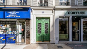 A storefront with a green door, a blue signboard advertising laser colors, and a white sign for a hair salon. - Blueground | Jardin des Plantes, nr Notre Dame (Paris)