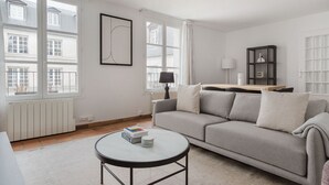En moderne stue med en grå sofa, et rundt sofabord og et minimalistisk design.