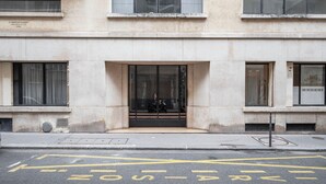 A building with a large entrance, a visible sign, and a wheelchair accessibility symbol on the ground. - Blueground | Passy, move-in-ready + furniture (Paris)