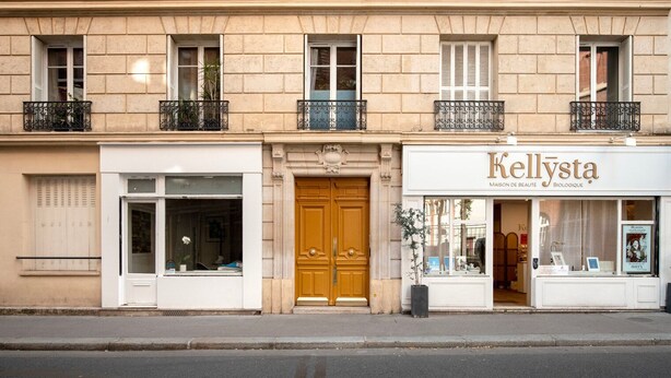 A building with a storefront named 'Kellysta' featuring a wooden door and a window display. - Blueground | Pasteur - Montparnasse, furnished (Paris)
