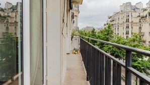 Un balcón con vistas a edificios y árboles circundantes.