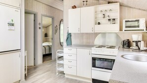 A compact kitchen with white cabinetry, a microwave, a kettle, and a coffee maker. - "Gorica" - 30km from the sea by Interhome (Toftlund)