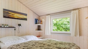 A bedroom with a bed, a window with curtains, a bookshelf, and a painting on the wall. - "Gorica" - 30km from the sea by Interhome (Toftlund)