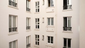 En bygning med flere etager, hvide ydervægge og mange vinduer, hvoraf nogle har balkoner.