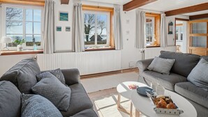 A cozy living room with two sofas, a coffee table with pastries, and large windows with curtains. - "Hakon" - 40m from the sea by Interhome (Nexø)