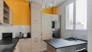 Una cocina moderna con encimera negra, armarios de madera y horno empotrado.
