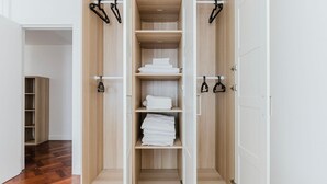 A walk-in closet with open shelving, a hanging rod, and a shoe rack. - Blueground | Invalides, nr embassies & museum (Paris)