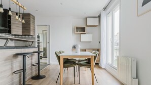 Eine moderne Küche mit Essbereich, Holzboden und einem großen Fenster für natürliches Licht.
