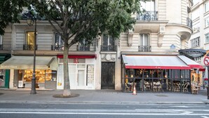 A street view with a restaurant named 'Maison Verot' and a shop with a red awning.