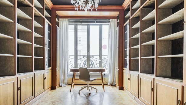 A room with wooden cabinets, a desk, and a chair.
