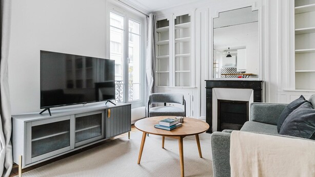 Ein modernes Wohnzimmer mit Fernseher, Kamin und einer gemütlichen Sitzecke.