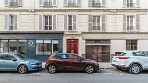 A row of parked cars in front of a building with multiple windows and shutters. - Blueground | Champ de Mars, near Eiffel Tower (Paris)