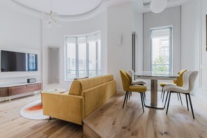 Relax in this stylish living space with a sofa set, dining table, and flat-screen TV.