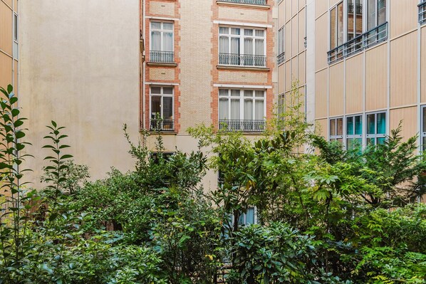 Stylish urban residence with balconies and lush green surroundings.
