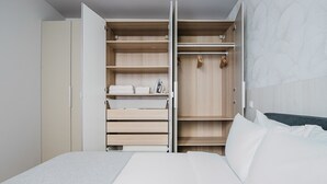 Une chambre à coucher comprenant un lit, une armoire avec plusieurs compartiments et une table de chevet.