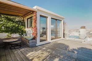 Enjoy the city view from this rooftop terrace with a seating area and sliding glass door leading to an indoor space.