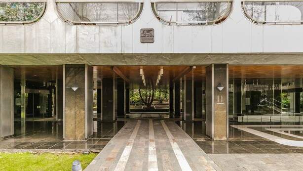 Une entrée moderne, avec un chemin central menant à une porte en verre.