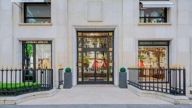 Fachada de edificio con escaparates de Giorgio Armani y Brunello Cucinelli.