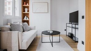 Una sala de estar moderna con sofá, mesa de centro, mueble para televisión y estanterías empotradas.