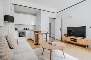 Cozy living area with a sofa, coffee table, and flat-screen TV.