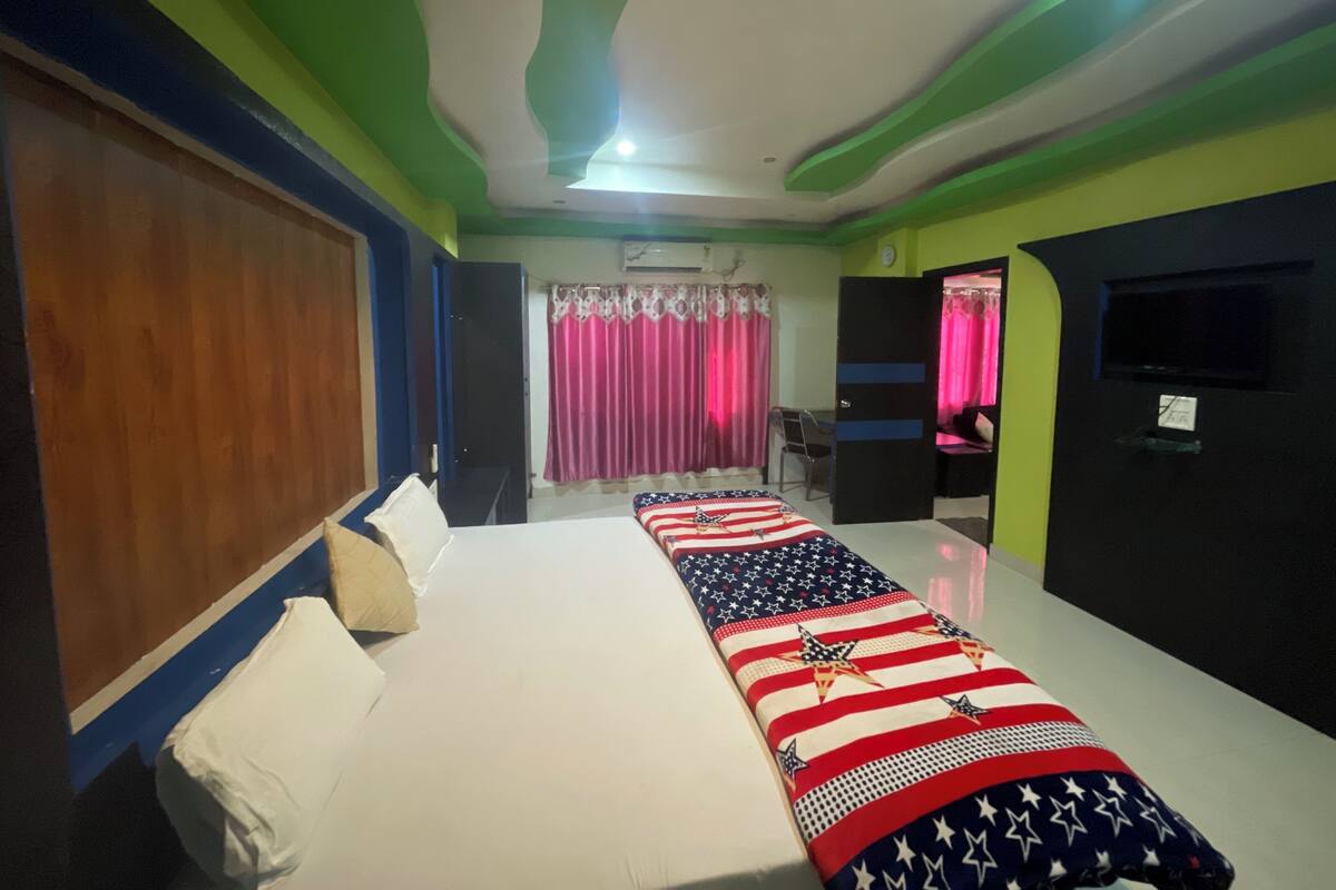 A hotel room with a bed, a desk, and a television.