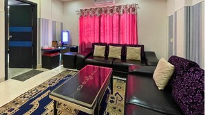 A modern living room with a sofa, a coffee table, and a television.