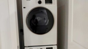 A laundry room with two stacked washers and dryers.