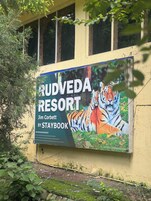 Un cartel publicitario del Resort Rudveda, presentado por Staybook, con la imagen de un tigre.