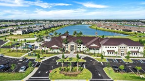 A residential area with a large building, a parking lot, and a body of water. - New Home in Paradise! (Fort Myers)